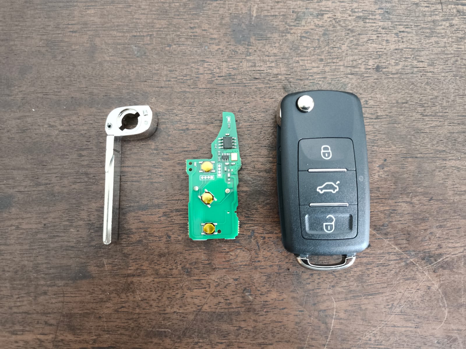 Chave canivete automotiva desmontada: lâmina, placa e carcaça